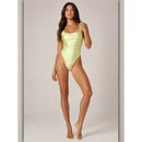 Woman wearing a light green swimsuit against a neutral background