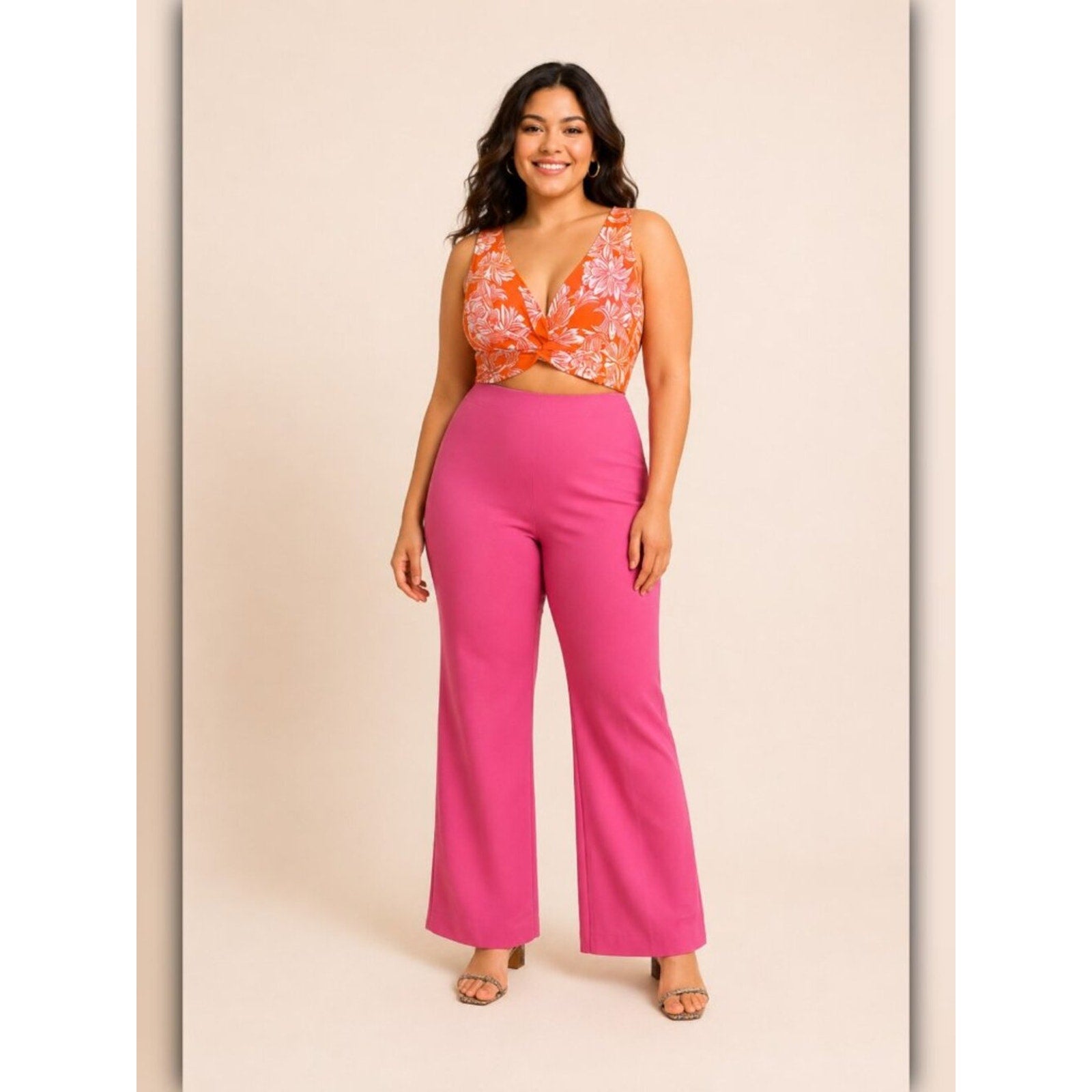 Woman wearing a floral top and pink pants on a beige background
