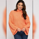 Woman wearing an orange sweater against a plain background