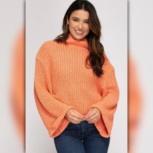 Woman wearing an orange sweater against a plain background