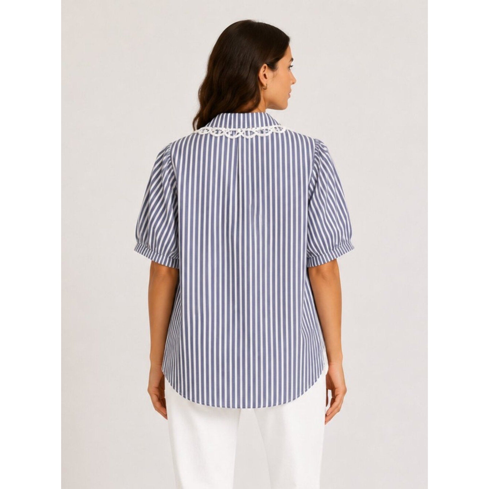 Woman wearing a blue and white striped shirt on a plain background