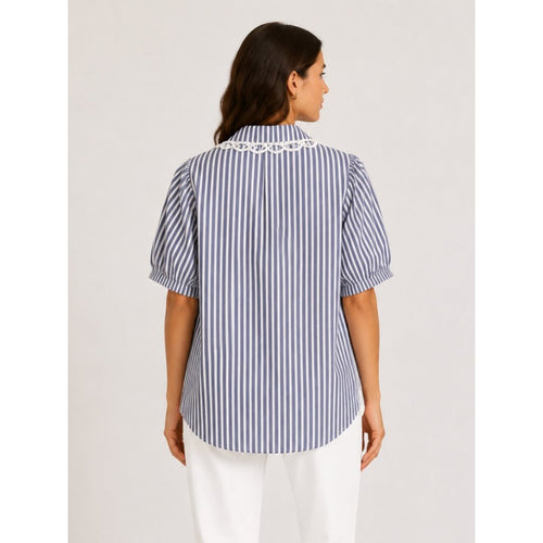 Woman wearing a blue and white striped shirt on a plain background