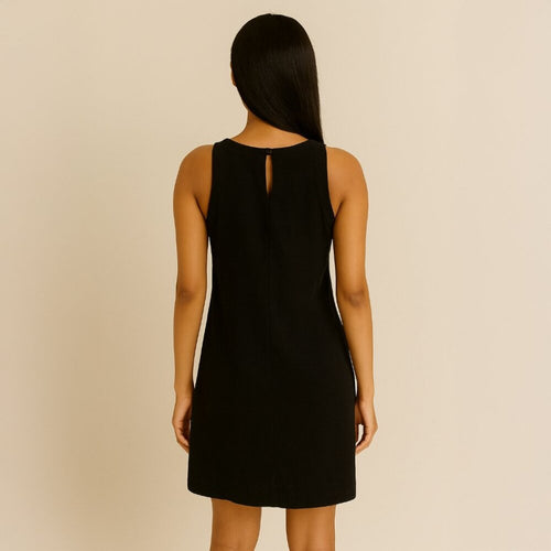 Black dress worn by a person on a beige background
