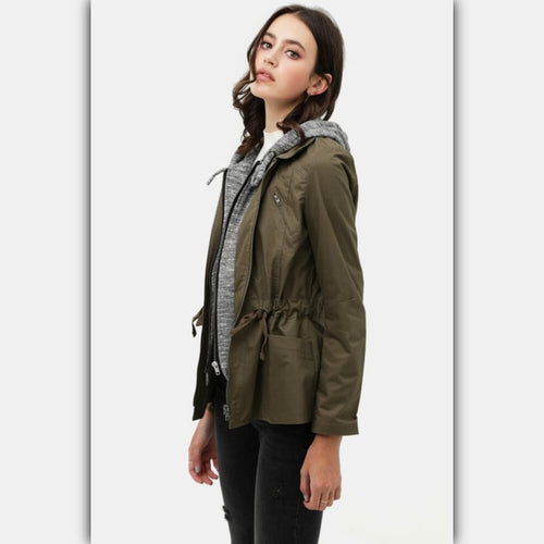 Woman wearing a green jacket with a hood on a white background