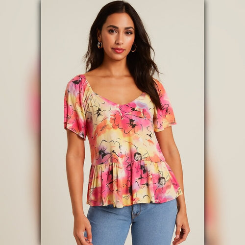 Woman wearing a colorful floral blouse against a neutral background